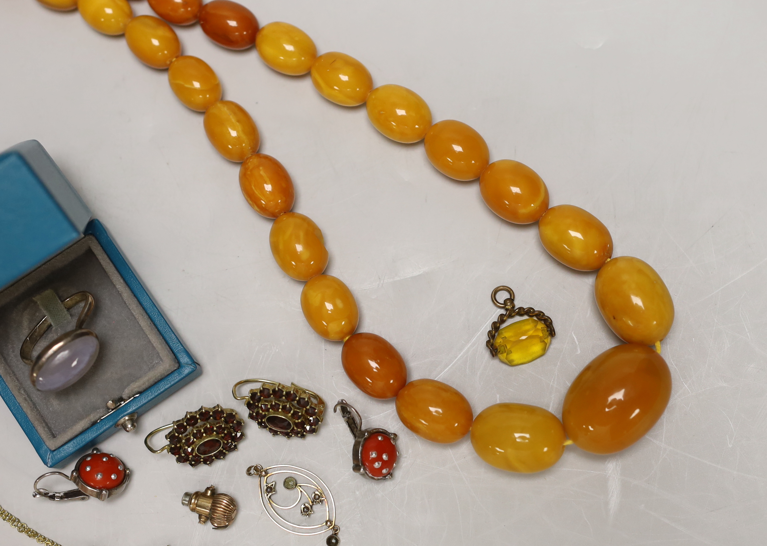 A single strand graduated oval amber bead necklace, 98cm, gross weight 94 grams and other sundry jewellery.
